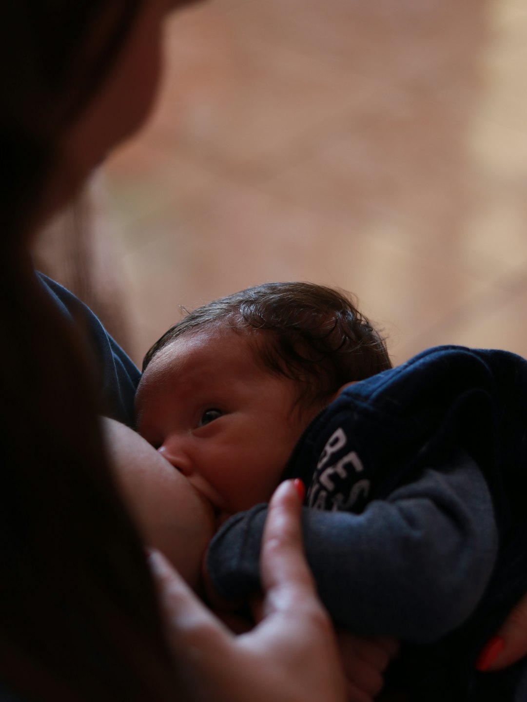 Eine Mutter stillt ihr Baby sanft im Arm.